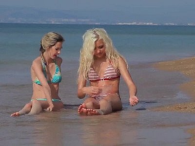 Two playful bikini whores get naked on the beach